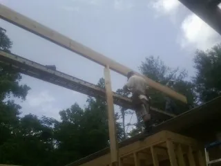 Carpenter setting a ridge beam over a new addition frame — Ice Dam Removal by Roofing Brothers in Lindon
