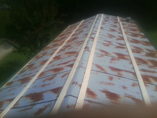 Rusted metal roof panels with new wood purlins before replacement — Storm Damage Roof Repair in Lindon by Roofing Brothers