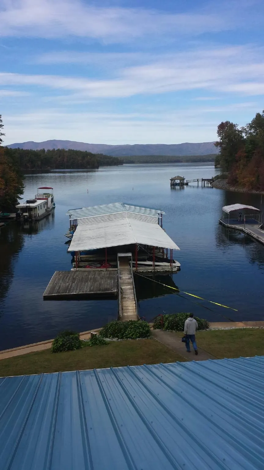 View across a lake from a newly installed blue metal roof in Lindon