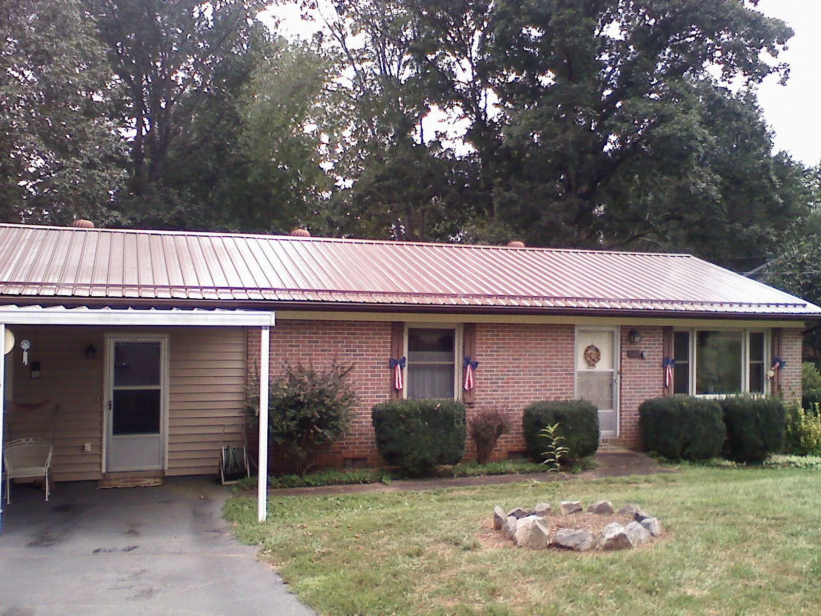 Bronze metal roof and carport on a brick ranch home — Roof Repair work by our crew in Lindon